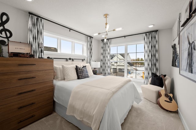 bedroom with light carpet, a chandelier, multiple windows, and a textured ceiling