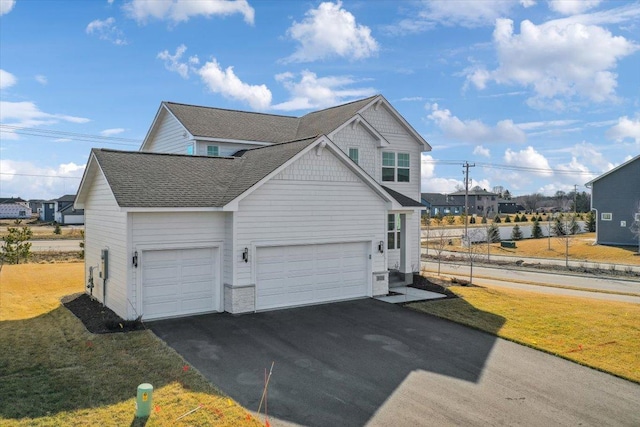 view of side of home with a yard and a garage