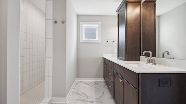 bathroom featuring a tile shower and vanity