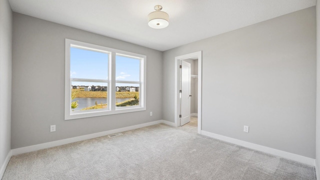 carpeted spare room with a water view