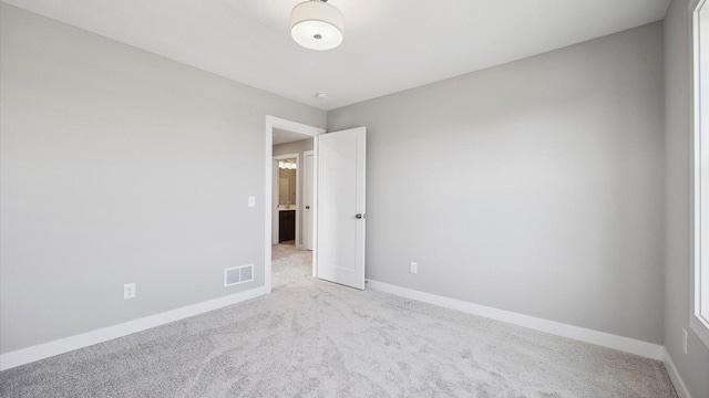 spare room featuring light colored carpet