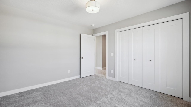 unfurnished bedroom featuring light carpet and a closet