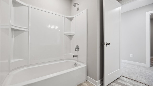 bathroom featuring wood-type flooring and shower / washtub combination