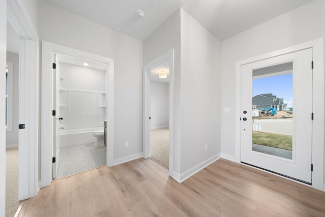 foyer with light hardwood / wood-style floors and a textured ceiling