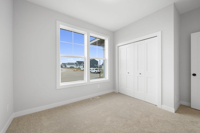 unfurnished bedroom with a closet and carpet flooring