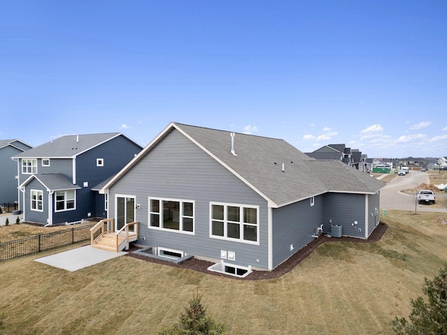 rear view of property with a yard and central air condition unit