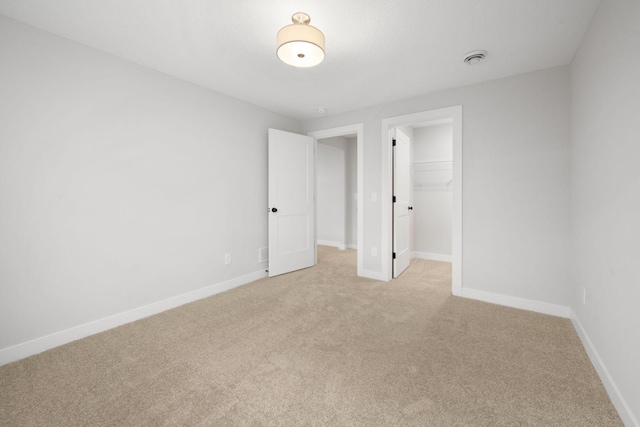10142 Arrowwood Trl, Woodbury, MN 55129 - unfurnished bedroom with light carpet, a spacious closet, and baseboards