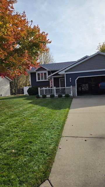 view of front of property with a garage, a porch, and a front yard