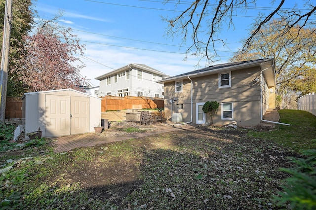 rear view of house with a storage unit