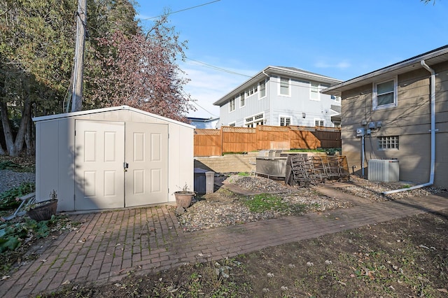 view of yard featuring central AC unit, a patio area, and a storage shed