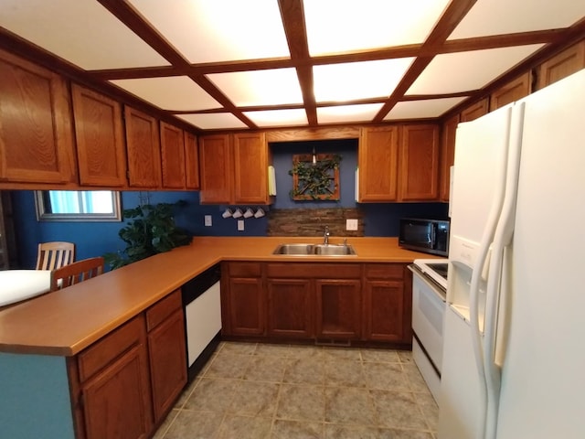 kitchen with light countertops, white appliances, brown cabinetry, and a sink