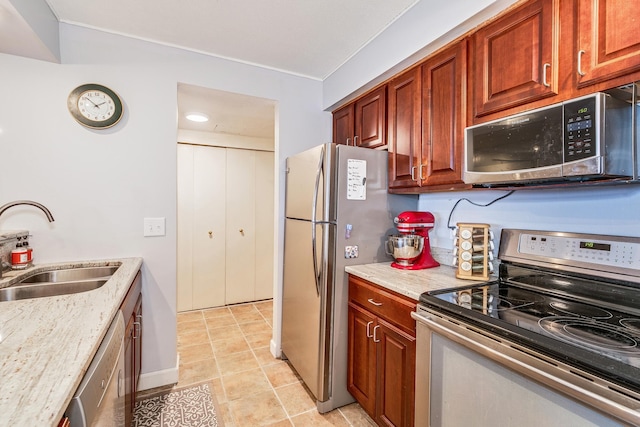 kitchen featuring light stone counters, sink, and stainless steel appliances