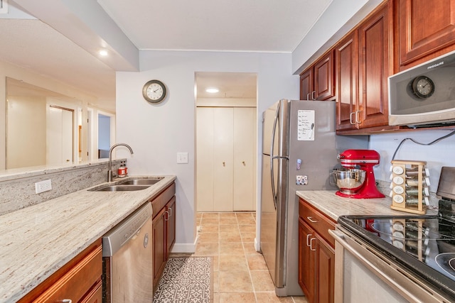 kitchen with light tile patterned flooring, stainless steel appliances, light stone counters, and sink