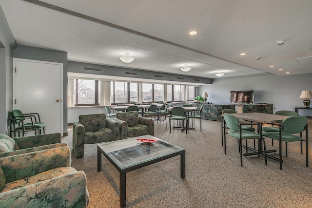 carpeted living room featuring a wealth of natural light and a textured ceiling