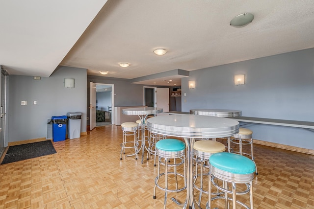 kitchen featuring a textured ceiling, light parquet floors, and a breakfast bar area