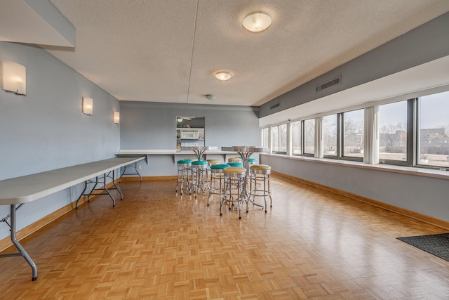 dining room with a textured ceiling and light parquet floors