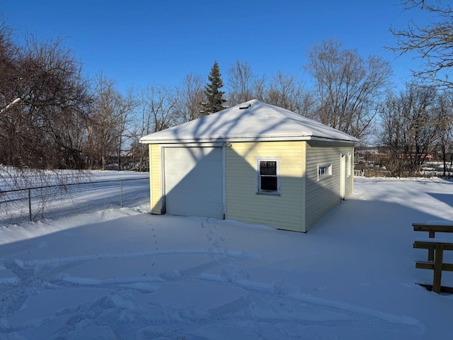 snow covered structure featuring a garage