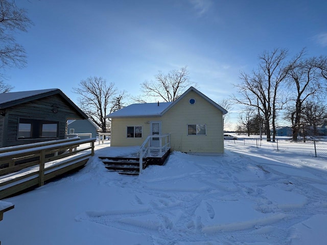 snow covered back of property featuring a garage