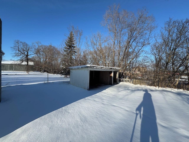 snowy yard featuring an outdoor structure