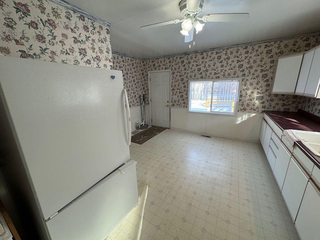 kitchen with ceiling fan, white cabinets, and white refrigerator