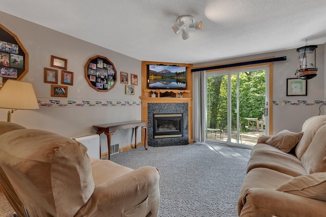 living room with a fireplace, carpet, and a textured ceiling