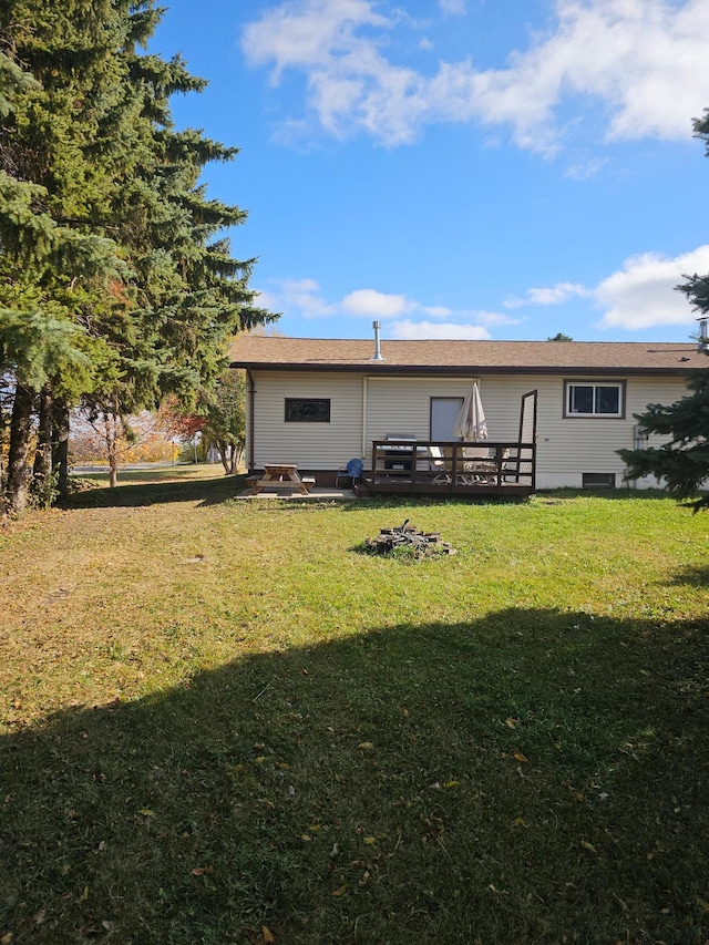 back of property with a lawn and a wooden deck