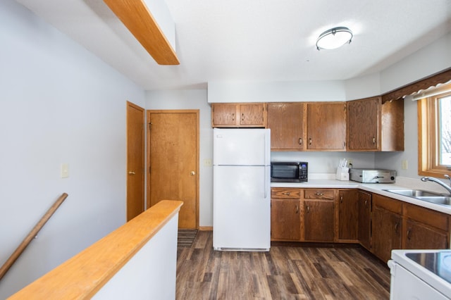 kitchen with sink, white fridge, and dark hardwood / wood-style floors