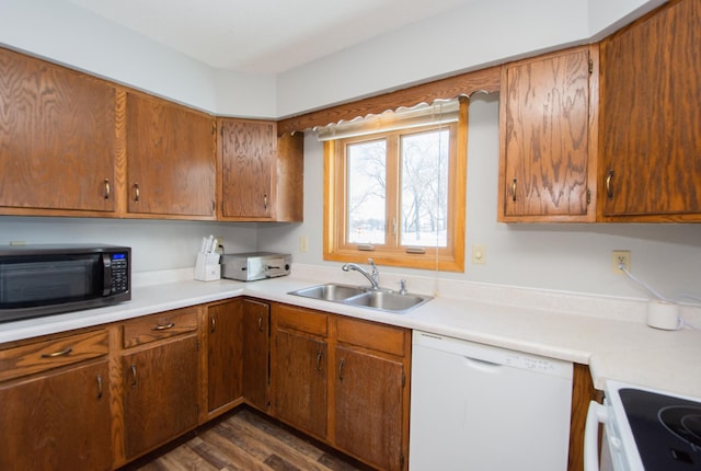 kitchen featuring range, dishwasher, dark wood-type flooring, and sink