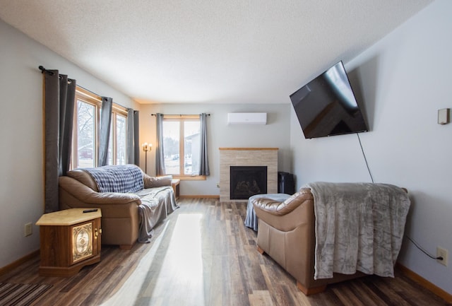 living room with a tile fireplace, a textured ceiling, dark hardwood / wood-style floors, and a wall unit AC