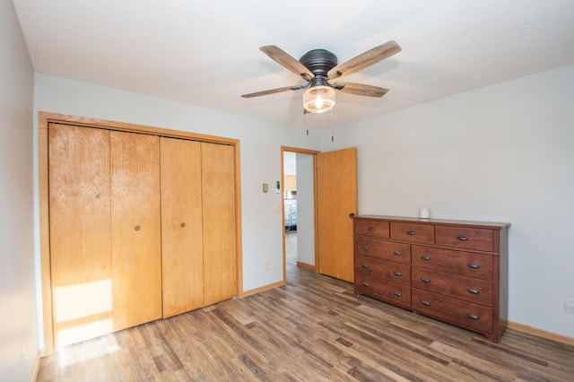 unfurnished bedroom with hardwood / wood-style floors, a closet, and ceiling fan