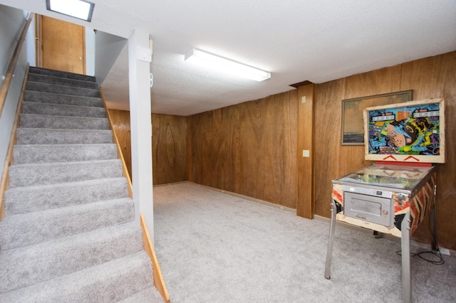 basement with wooden walls and light colored carpet