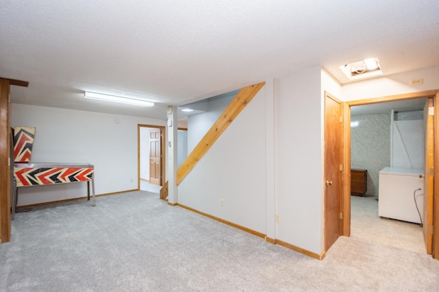 basement featuring light carpet and a textured ceiling