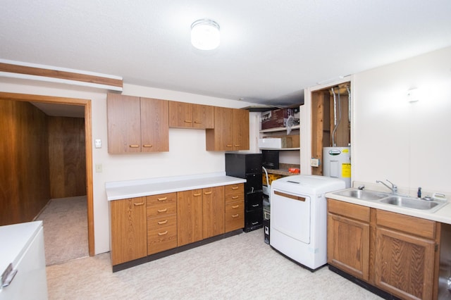 kitchen featuring washer / dryer, electric water heater, and sink