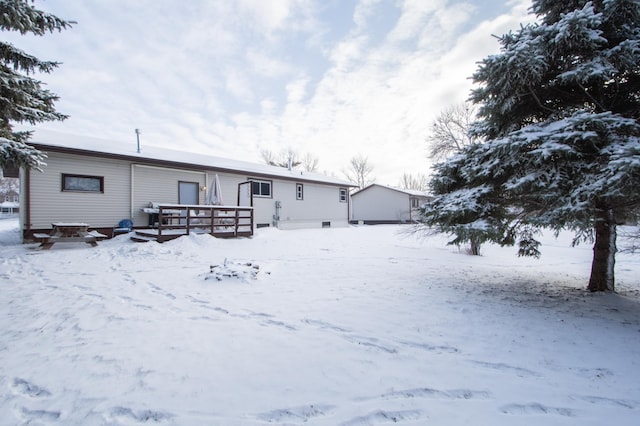 snow covered property with a wooden deck