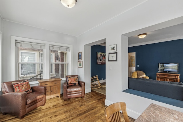 living area featuring crown molding and wood-type flooring