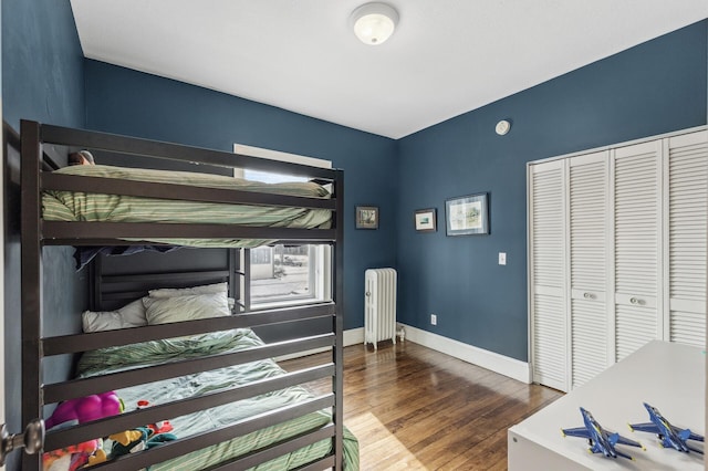 bedroom featuring hardwood / wood-style flooring, radiator, and a closet