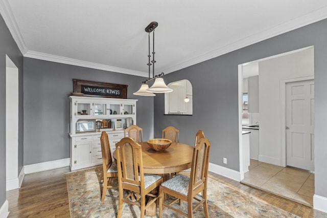 dining area with hardwood / wood-style flooring and crown molding