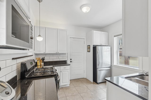 kitchen featuring white cabinetry, appliances with stainless steel finishes, sink, and decorative light fixtures