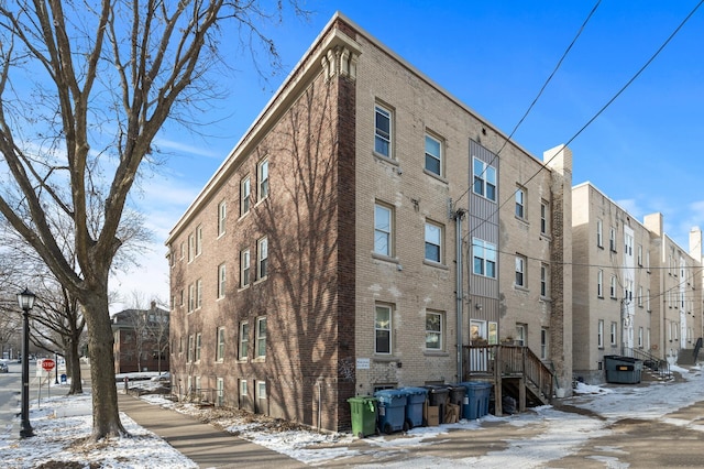 snow covered property with central air condition unit