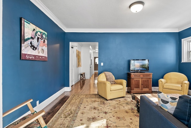 living area featuring baseboards, ornamental molding, and wood finished floors