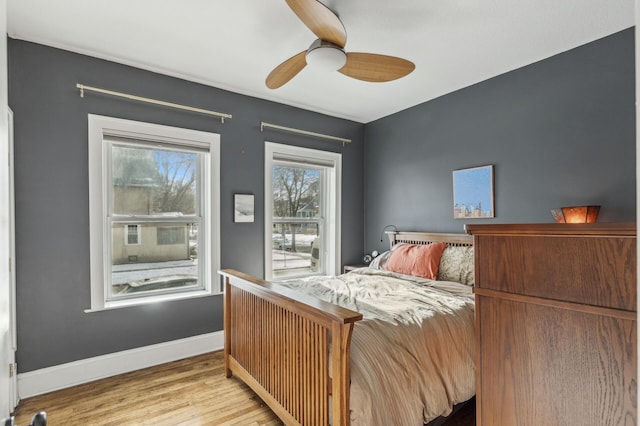 bedroom featuring a ceiling fan, baseboards, and wood finished floors