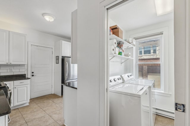 washroom with laundry area, independent washer and dryer, baseboard heating, and light tile patterned floors