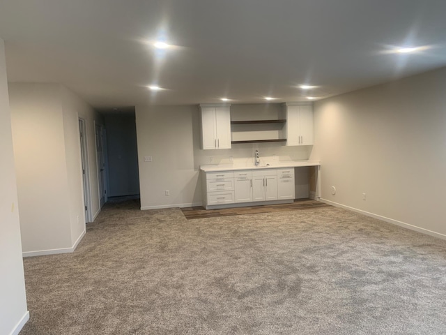 kitchen featuring white cabinetry and light colored carpet