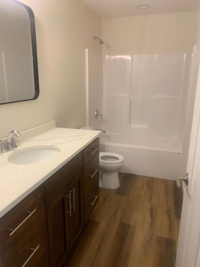 full bathroom featuring vanity, hardwood / wood-style flooring, bathing tub / shower combination, and toilet