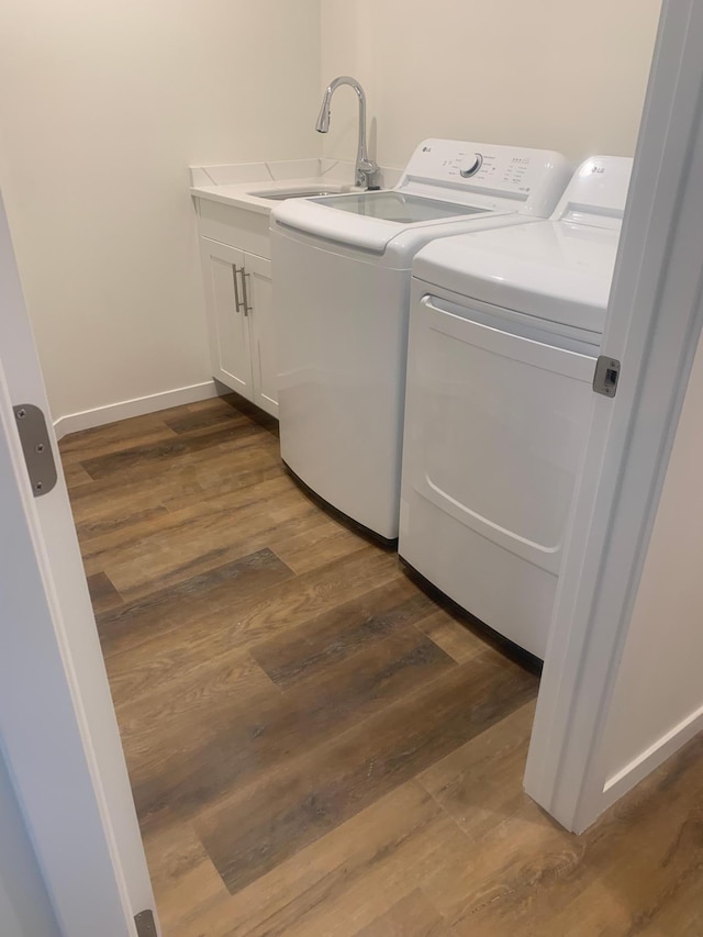 washroom with sink, washer and clothes dryer, cabinets, and dark hardwood / wood-style floors