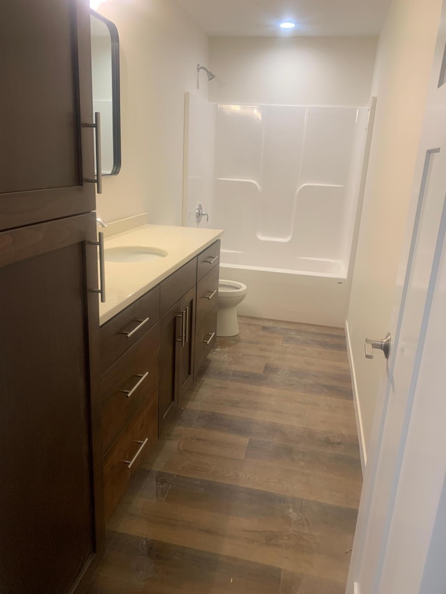 full bathroom featuring vanity, hardwood / wood-style flooring, shower / tub combination, and toilet