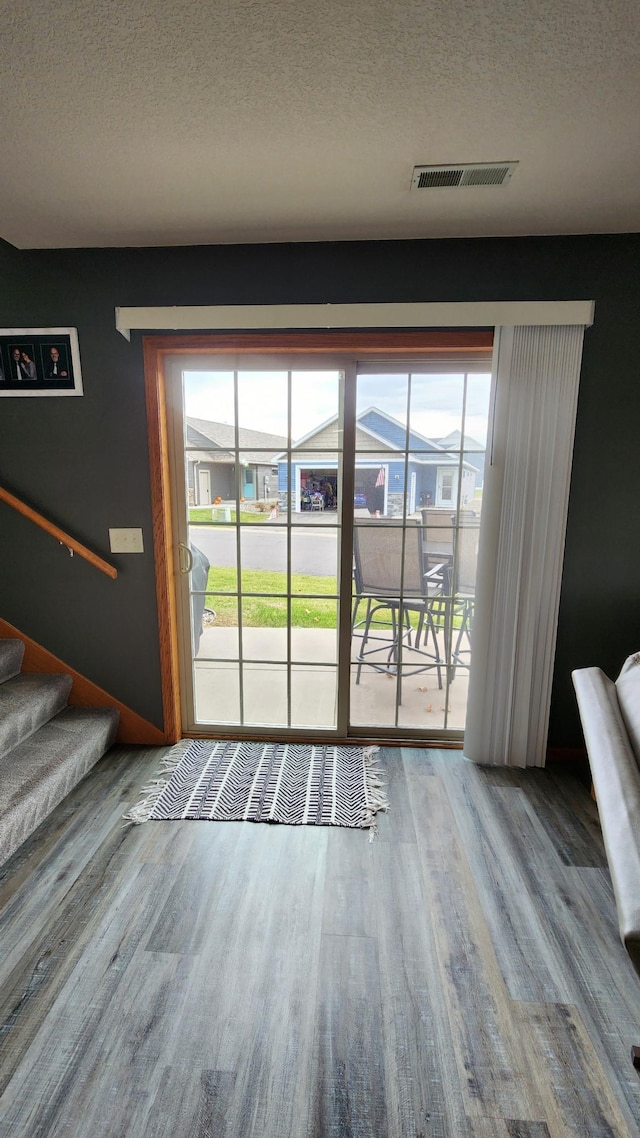 entryway with plenty of natural light, hardwood / wood-style floors, and a textured ceiling