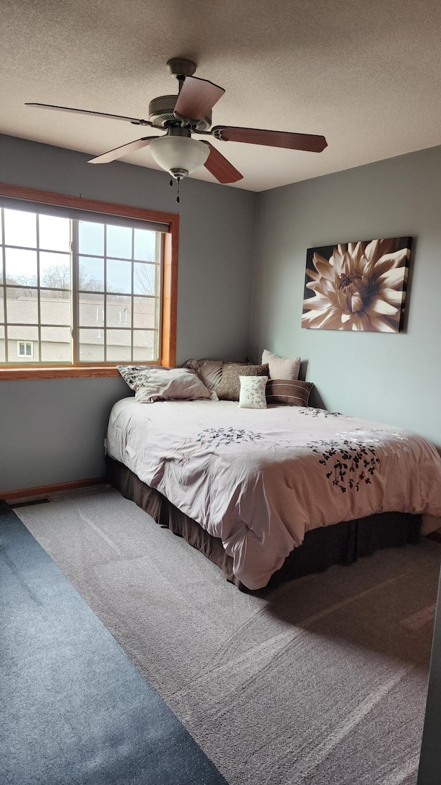 bedroom with carpet flooring, a textured ceiling, and ceiling fan