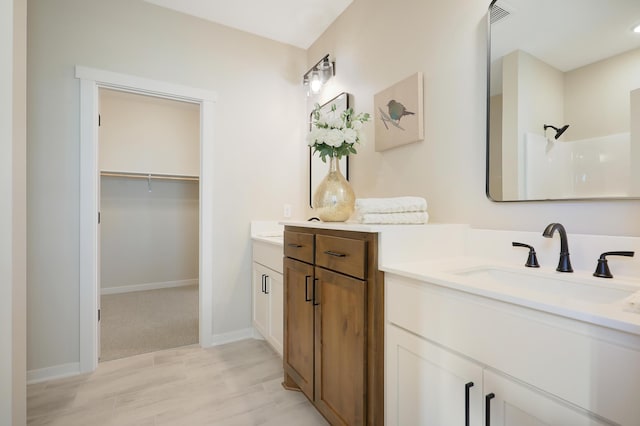 bathroom featuring a shower, hardwood / wood-style floors, and vanity