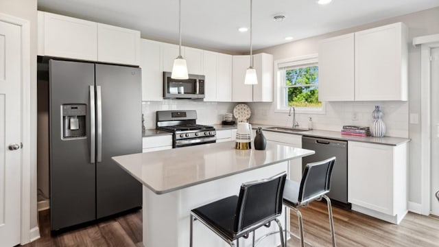 kitchen featuring appliances with stainless steel finishes, white cabinetry, and sink